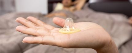 Una mujer con un preservativo en la mano
